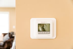 a thermostat on a peach wall