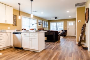 a kitchen and living room with hardwood floors and yellow walls