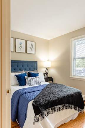 A bedroom with a bed covered in a blue blanket.
