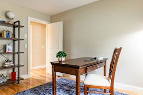 A room with a desk, chair, and bookshelf.