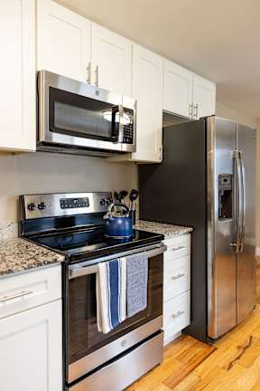 A kitchen with a black refrigerator, stove, and oven.