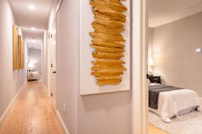 A long hallway with a large yellow sculpture on the wall.