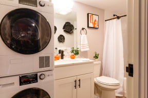 a bathroom with a toilet and a washer and dryer in it