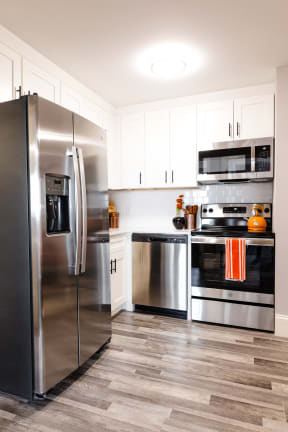 a modern kitchen with stainless steel appliances and white cabinets