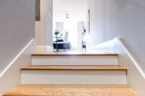 A staircase with wooden steps and a white landing.