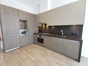 A modern kitchen with wooden cabinets and a stainless steel oven.