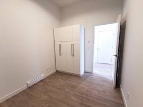 A room with a white door and a black refrigerator.