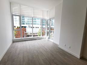 A room with a view of a cityscape through large windows.