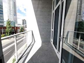 A balcony with a metal railing overlooks a city street.