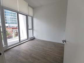 A room with a large window and a wooden floor.