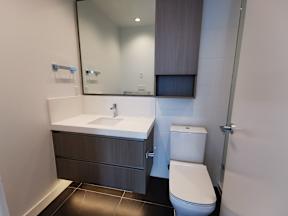 A white toilet sits next to a sink in a modern bathroom.
