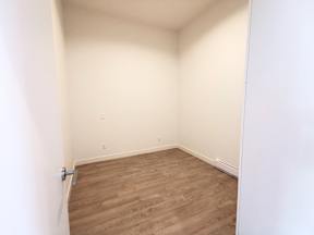 A room with wooden flooring and white walls.