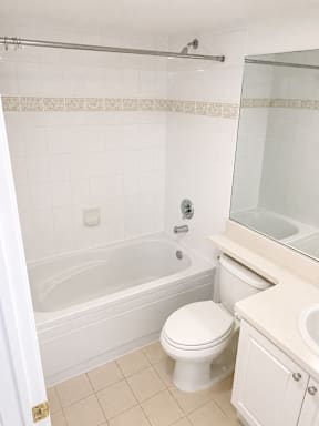 A white bathroom with a toilet, sink, and bathtub.