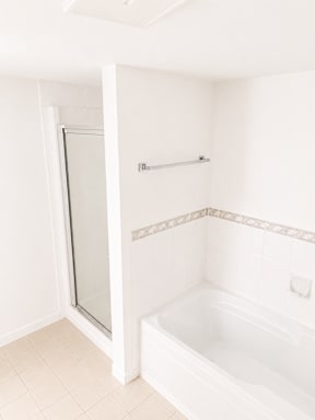 A white bathroom with a tub and shower.