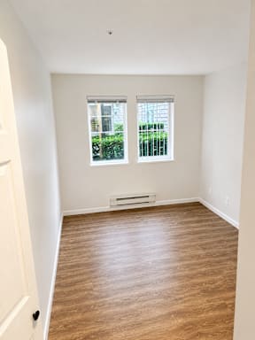 A room with a window and a radiator on the floor.