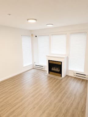 A room with a fireplace and wooden flooring.