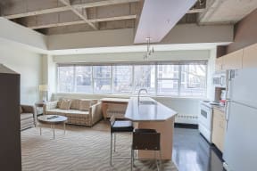 a living room with a kitchen and a large window