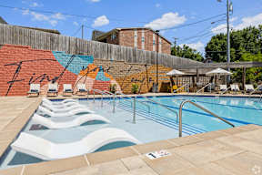 A pool with a mural on the wall and a wooden fence.