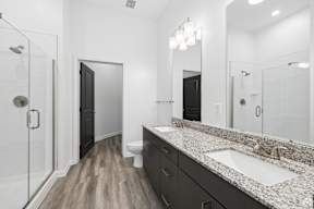 A bathroom with a sink, mirror, and shower.