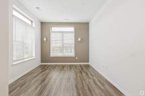A room with a window and wooden flooring.