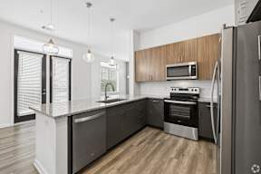 A modern kitchen with a refrigerator on the right side.