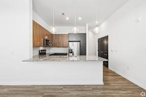 A modern kitchen with a white island and wooden cabinets.