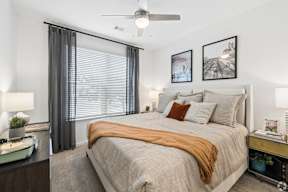 A bedroom with a large bed and a ceiling fan.