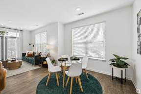A dining room with a table and chairs.