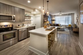 kitchen and living room of a model home with stainless steel appliances
