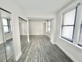 an empty living room with wood floors and windows