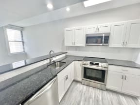 a kitchen with granite counter tops and stainless steel appliances