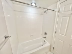 a white bathroom with a shower and a tub