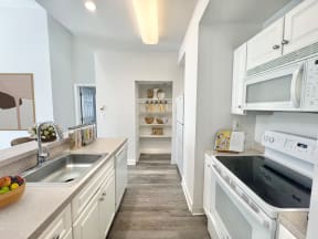 a renovated kitchen with white appliances and white cabinets