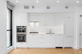 a white kitchen with white cabinets and a window