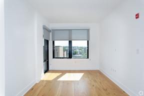 Secondary bedroom with a window and wood floors