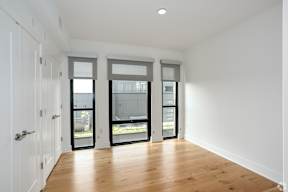 Secondary Bedroom 
with a hardwood floor and white walls and a door with windows