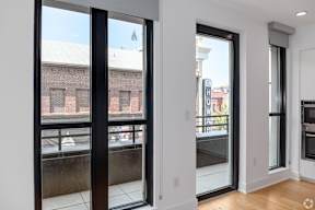 a living room with large windows and a view of a brick building