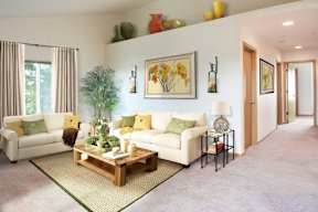 A living room with a white couch, a coffee table, and a painting on the wall.