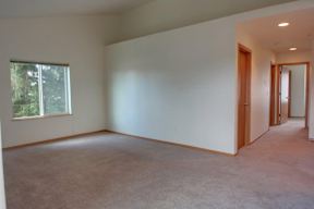 Empty room with carpeted floor and white walls.