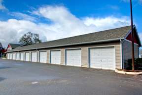 A building with a grey roof and white garage doors.