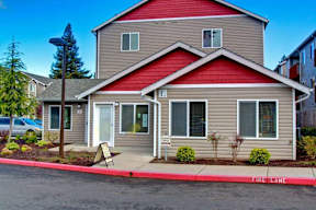 A house with a red roof and a sign that says "Fire Lane" in front of it.