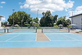 A tennis court with a net and two benches.