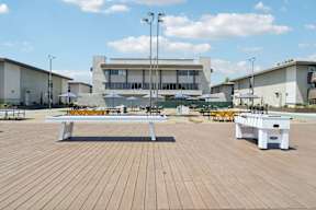 A wooden table is in the middle of a wooden deck.