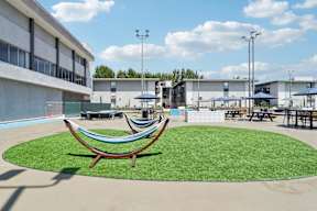 A hammock sits in the middle of a grassy area.
