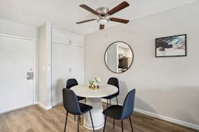 A dining room with a white table and four chairs.