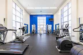A gym with treadmills, elliptical machines, and other exercise equipment.