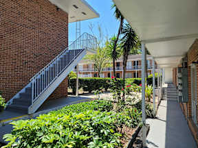 A staircase with a metal railing leads up to a building.