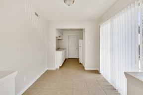 A white kitchen with a long hallway.