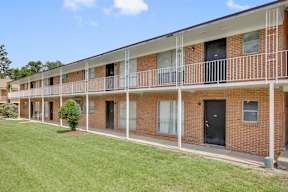A long brick building with balconies and doors.