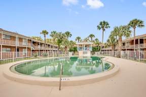A pool in the middle of a courtyard surrounded by buildings.